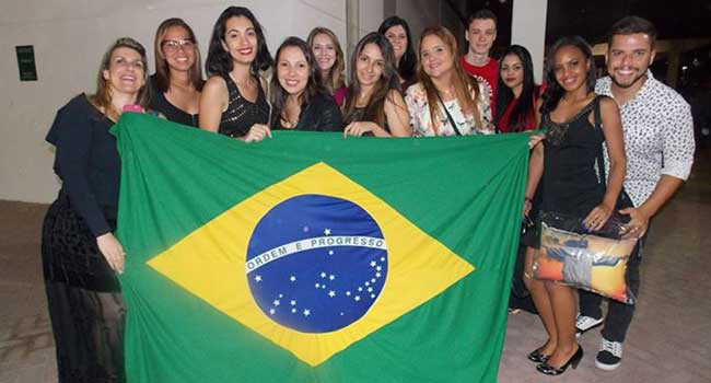 Os fãs mais ilustres do cantor segurando a bandeira brasileira no show no Rio de Janeiro